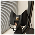 Detail of black minimalist square handbag featuring a prominent gold pyramid stud buckle - Black