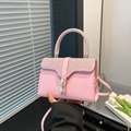 Borsa a mano rosa con strass, chiusura girevole dorata e tracolla in un ambiente moderno - Rosa
