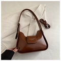 Detail of a brown glossy hobo bag with a removable strap and printed fashion text - Light Brown