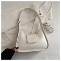 Detalle del bolso hobo crema con textura de cuero y correa sobre una chaqueta de pana - Blanco