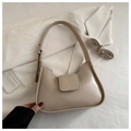 Detalle del bolso de cuero PU crema con texto grabado sobre tela blanca texturizada - Caqui