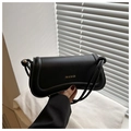 Detalle de solapa ondulada y asa de cuerda anudada de bolso de hombro negro elegante - Negro