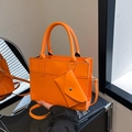 Minimalistische leuchtend orangefarbene Ledertasche mit passender Geldbörse und Gurt - Orange