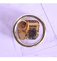 Draufsicht auf die goldene Handkurbel-Spieluhr-Mechanik mit transparenter Schutzhülle - Gold