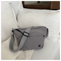 Detail of grey nylon crossbody bag with adjustable wide strap and metallic logo accent - Gray