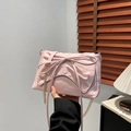 Pink pleated crossbody bag featuring a large bow detail and golden chain strap - Pink