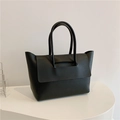 Detailed view of the black matte leather tote bag with flap closure and dual top handles - Black