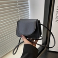 Mini bolso bandolera negro de cuero sintético granulado sostenido en la mano - Negro