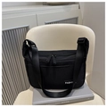 Dettaglio della borsa a tracolla in nylon nero con etichetta fashion e doppia zip - Nero