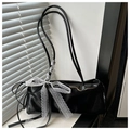 Détail d'un sac à bandoulière noir brillant orné d'un grand nœud en dentelle blanche - Noir