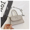 Detail of silver glitter mini bag featuring a metallic bow buckle and chain strap - Gold