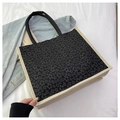 Chic beige linen tote bag with black floral print and woven handles for spring fashion - Black