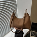 Brown woven texture hobo bag with gold hardware shown in a minimalist office setting - Brown