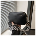 Detail of black crossbody bag featuring gold-tone hardware and chic geometric strap - Black