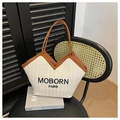 Detail van geweven draagtas met MOBORN PARIS borduursel en bruine leren hengsels - Bruin