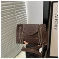 Detail of dark brown snakeskin embossed handbag with elegant gold chain shoulder strap - Brown