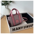 Détail d'un sac à main rose pailleté avec poignée et logo THE BAG dans son coffret cadeau - Rose