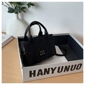 Détail d'un sac cabas noir à paillettes avec texte dans un décor de style de vie chic - Noir
