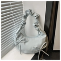 Detalle del bolso de media luna azul claro con asa rizada y detalles de lazos - Azul