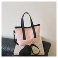 Light pink mini tote bag with black straps on white books for urban daily commuting - Pink