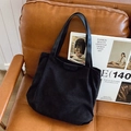 Classic black corduroy tote bag for women featuring stylish leather handles and fashion label - Black
