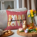 Funda de cojín de conejo de Pascua naranja con tipografía en un sofá blanco suave - Letras BUNNY Rojo Coral (YME24-4)