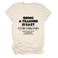 Flach liegendes beiges Baumwoll-T-Shirt mit Lehrer-Spruch und Rundhalsausschnitt - S / Sandfarben (Schwarze Schrift)