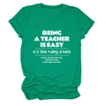 Close-up of green crew neck teacher T-shirt with humorous white quote print and rolled sleeves - Dark Green (White Font)