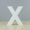 Minimalist white wooden decorative letter X on a marble surface with reflections - Letter X