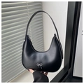 Detail of a black crescent shoulder bag featuring a decorative silver bow metal accent - Black