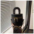 Detail einer schwarzen Eimertasche mit weißen Kontrastnähten und goldener Metallkette - Schwarz