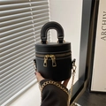 Schwarze Mini-Zylindertasche mit Doppel-Reißverschluss und goldener Kette in der Hand - Schwarz