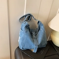 Retro denim tote bag in blue wash featuring adjustable metal buckles and frayed edges - Light Blue