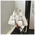 Close-up of white leather handbag featuring dual buckle straps and silver metal hardware - White