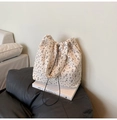 Detalle de bolso tote floral con textura de burbujas y cordón sobre libros blancos - Gris