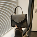 Elegante borsa a tracolla nera con dettagli in frangia e tracolla a catena dorata - Nero