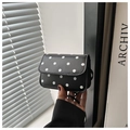 Detail of a vintage-style red polka dot crossbody bag with magnetic flap and slim strap - Black