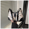 Détail du sac bandoulière à motif cerises avec bordures en cuir noir et fermoir doré - Noir