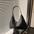 Minimalist black gloss shoulder bag with fashion embossing shown in hand - Black