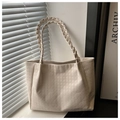 Detalle del bolso tote crema con relieve de pata de gallo y asas trenzadas en la ventana - Blanco