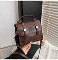 Detail van vintage bruine PU-lederen handtas met reliëfster en metalen sluiting - Donkerbruin
