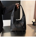 Close-up of black leather tote bag with large bow and silver heart pendant - Black