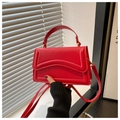 Detailansicht der roten Tasche mit gewellter Klappe und goldenem Verschluss im 45-Grad-Winkel - Rot