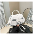 Detalle de bolso de mano en cuero blanco con solapa ondulada y hebilla dorada - Blanco
