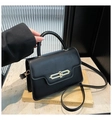Detail view of black matte handbag with gold circular metal clasp and slim shoulder strap - Black