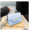 Detail of light blue crossbody bag featuring gold-tone hardware and smooth leather texture - Blue