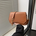 Bolso bandolera marrón minimalista con solapa curva y detalles de cadena dorada - Marrón