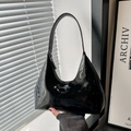 Minimalist black patent leather hobo bag with silver brand logo and sleek gloss finish - Black