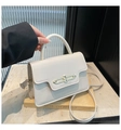 Detail of cream leather handbag with gold buckle, handle, and slim shoulder strap - Off White