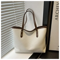 Detalle del bolso tote tejido blanco con asas de cuero marrón y remaches dorados - Blanco